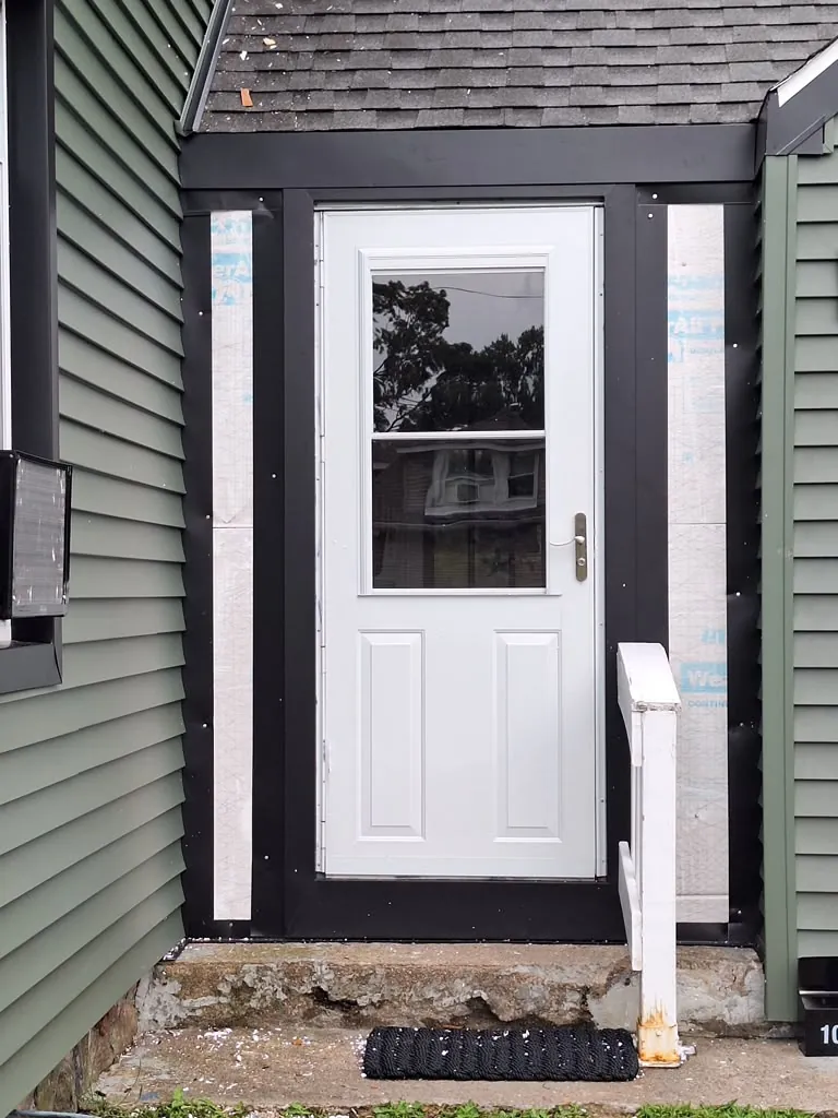 New exterior door installation with black trim surround