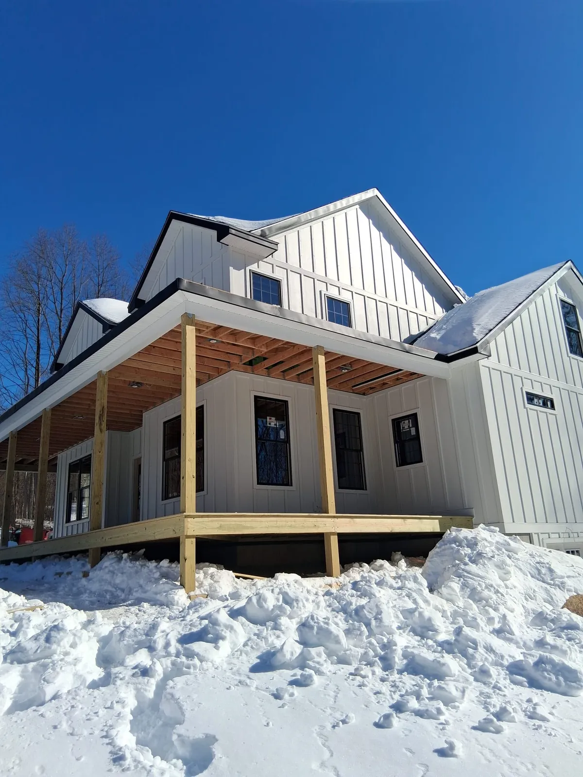 Farmhouse covered porch framing under construction in winter