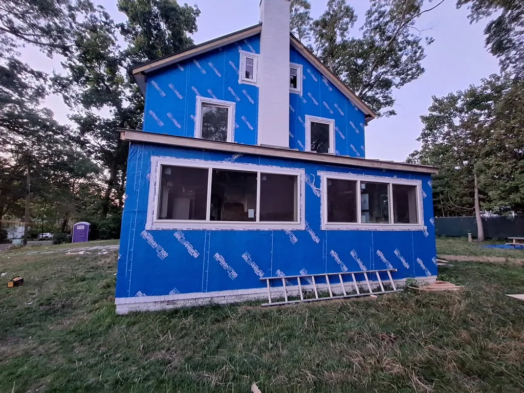House wrap and window installation on a home addition at dusk