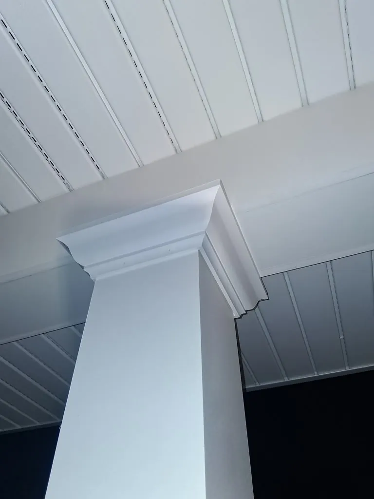 Close-up of a porch column capital and beadboard ceiling trim