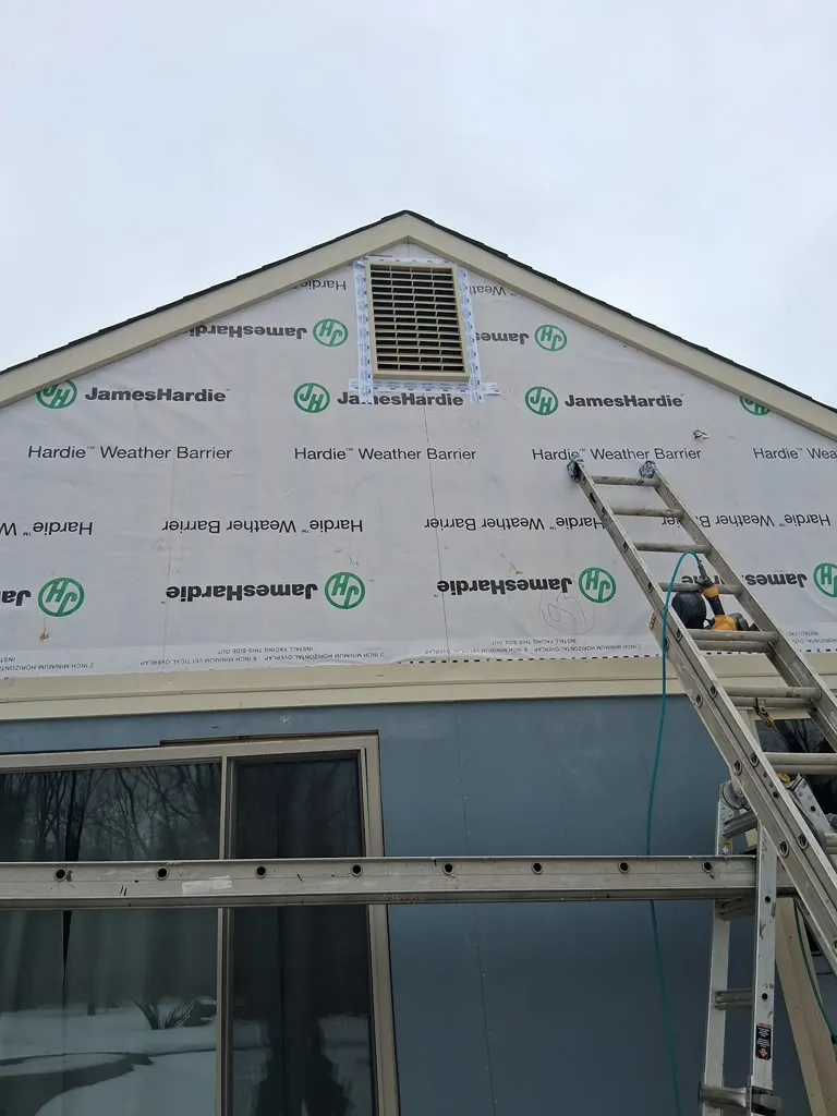 Completed white siding on a two-story home at sunset